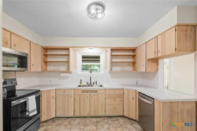 a kitchen with a sink cabinets and window