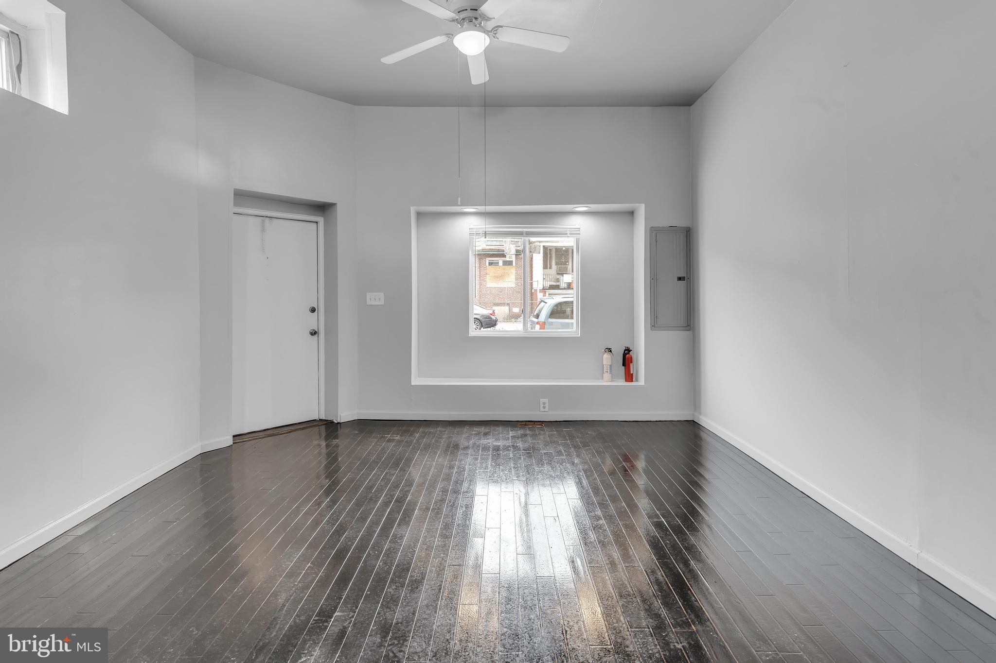 434 South 56th Street, Unit A Philadelphia, PA 19143 - Photo 11 of 19 an empty room with wooden floor chandelier fan and windows