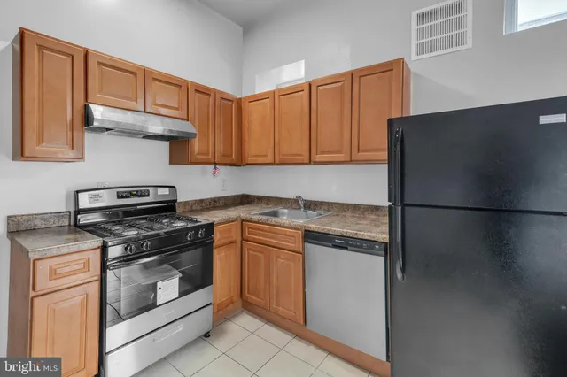 a kitchen with stainless steel appliances granite countertop a stove a refrigerator and a cabinets