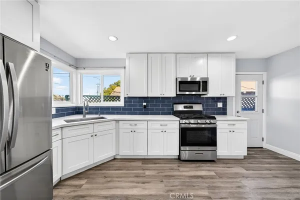 a kitchen with stainless steel appliances granite countertop a stove a sink and a refrigerator