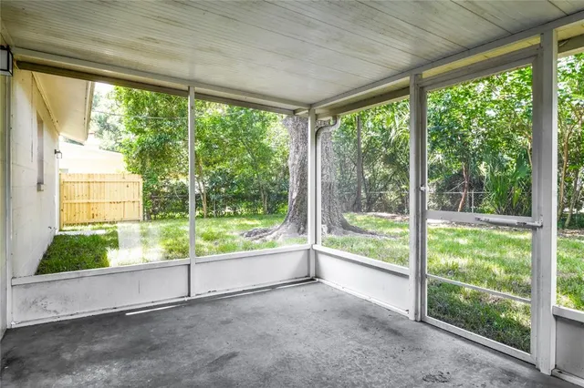 a view of an empty room with large windows and garden view