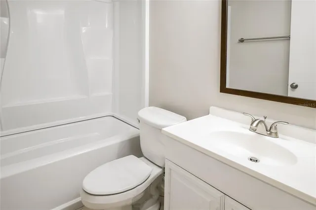 a white toilet sitting next to a bathroom sink