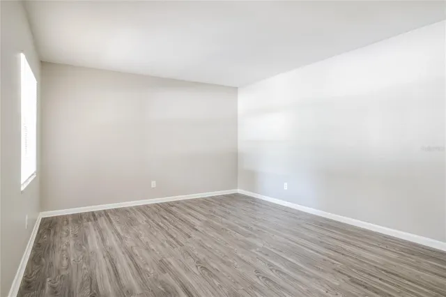 a view of an empty room with wooden floor