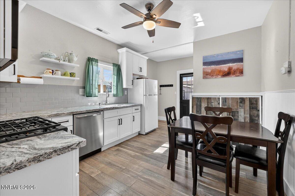 317 South Center Street Yerington, NV 89447 - Photo 9 of 27 a kitchen with stainless steel appliances granite countertop a stove a sink dishwasher and a dining table with wooden floor
