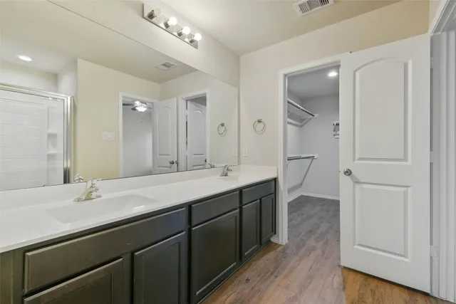 a bathroom with a double vanity sink a mirror and a shower
