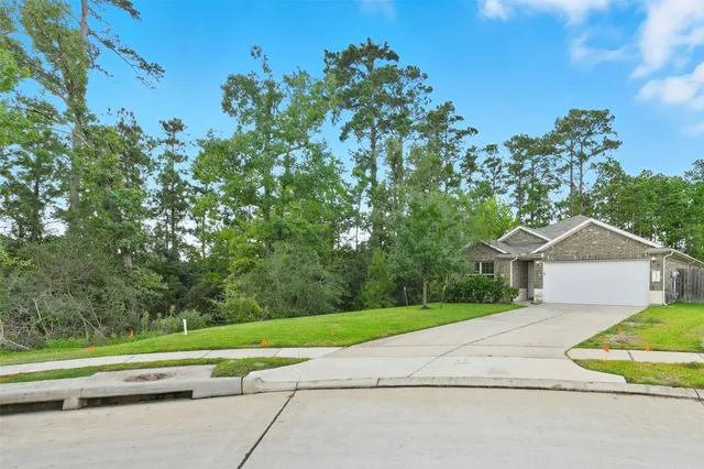 a view of a house with a yard and large trees
