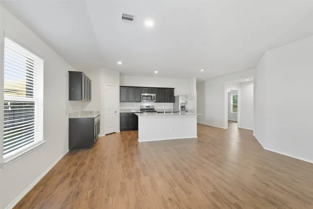 a view of kitchen with refrigerator stove and wooden floor