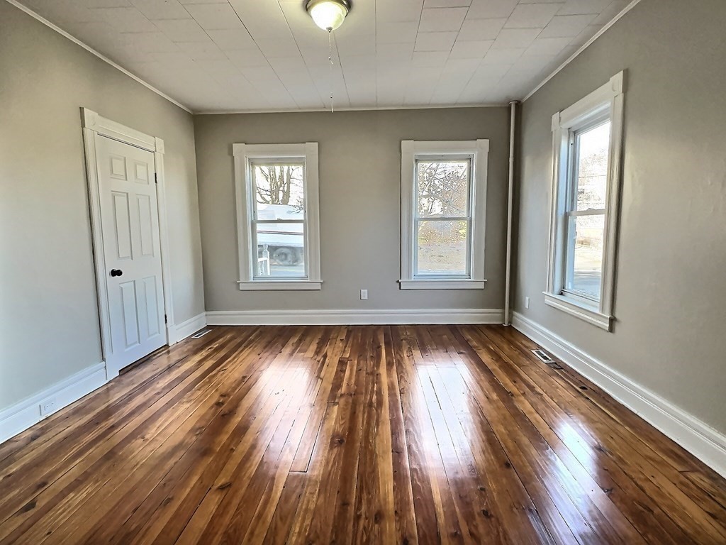 83 Oak Street Springfield, MA 01151 - Photo 7 of 18 a view of an empty room with wooden floor and window