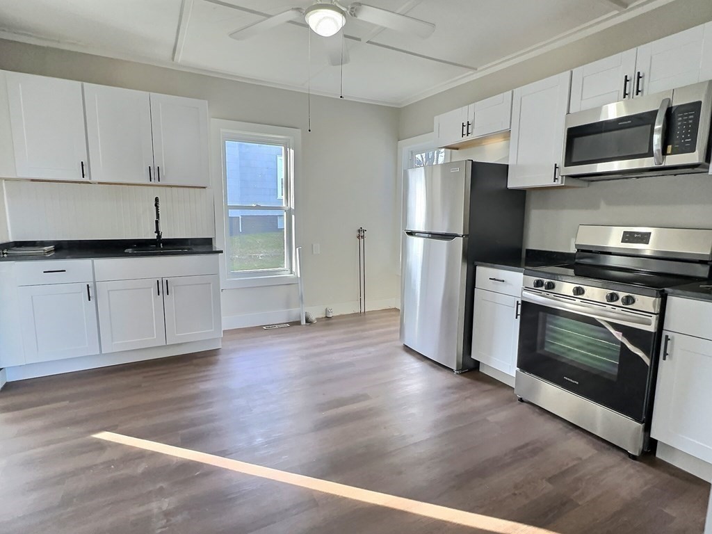 83 Oak Street Springfield, MA 01151 - Photo 9 of 18 a kitchen with stainless steel appliances a stove a microwave and sink