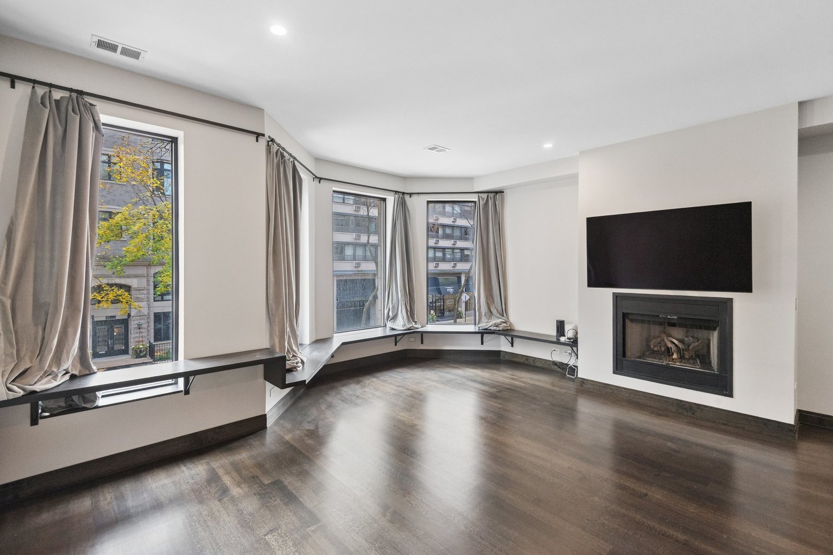 44 East Cedar Street Chicago, IL 60611 - Photo 12 of 35 a view of an empty room with window wooden floor and a fireplace