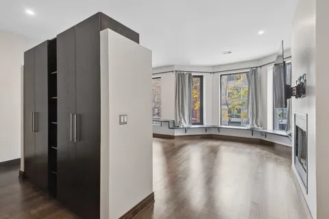 a view of an empty room with a window and wooden floor