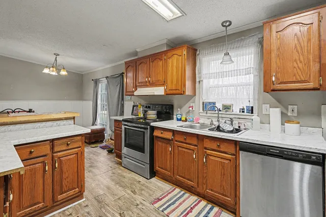 a kitchen with stainless steel appliances granite countertop a sink stove and cabinets
