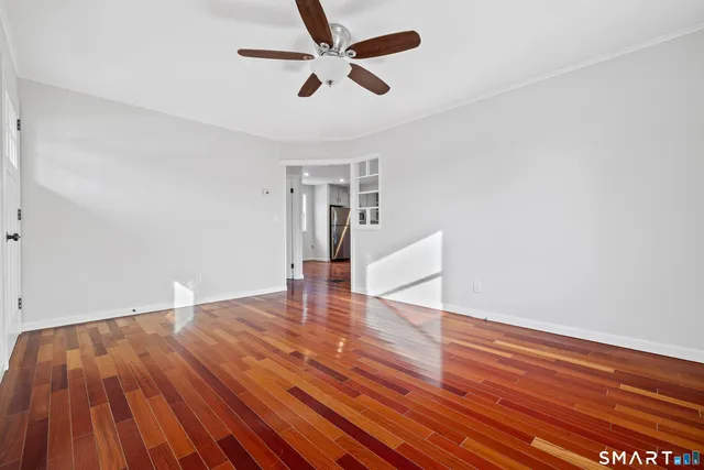 a view of empty room with wooden floor