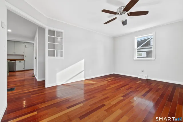 a view of empty room with wooden floor