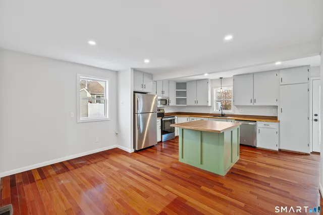 a kitchen with stainless steel appliances granite countertop a refrigerator and a sink
