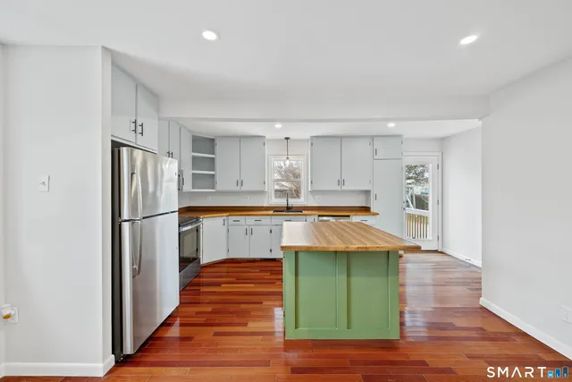 a kitchen with kitchen island a refrigerator sink and cabinets