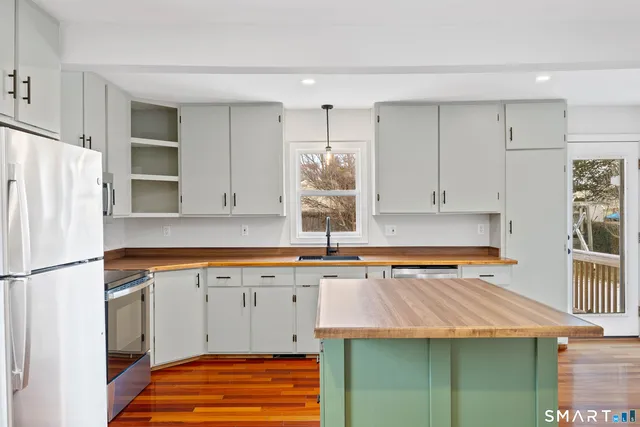 a kitchen with a sink a refrigerator and window