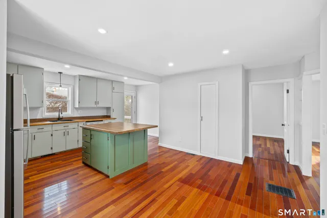 a kitchen with wooden floors and appliances