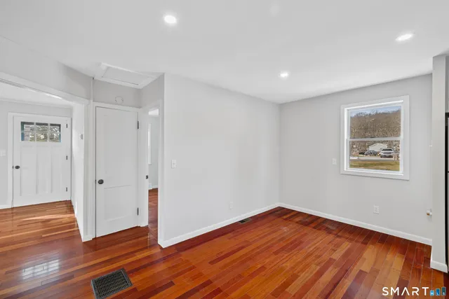 a view of a room with wooden floor and window