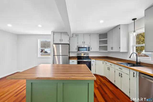 a kitchen with stainless steel appliances a sink stove and refrigerator