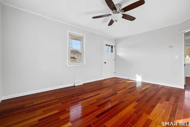 a view of empty room with wooden floor