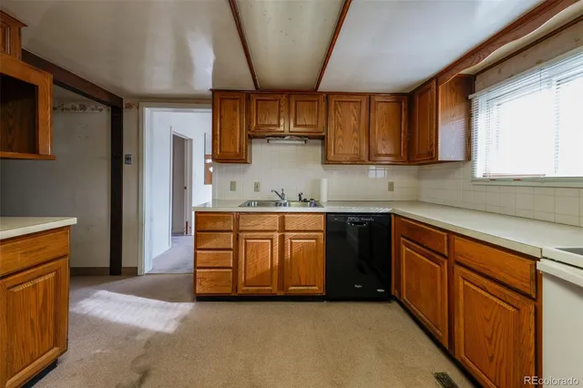 a kitchen with stainless steel appliances granite countertop a sink a stove a refrigerator cabinets and a window