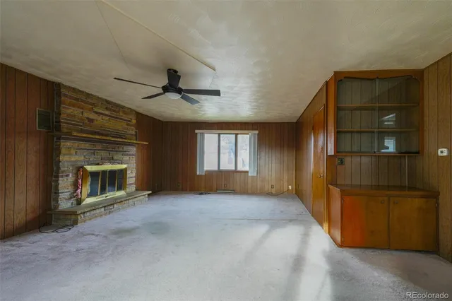 an empty room with windows and a fireplace