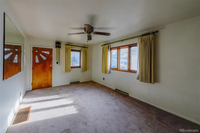 an empty room with windows and cabinet
