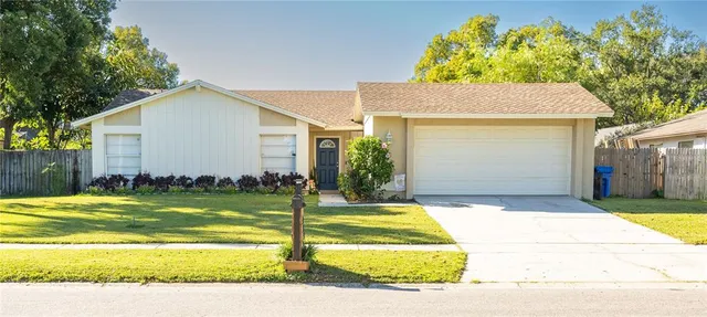 a front view of house and yard with beautiful flowers and green space
