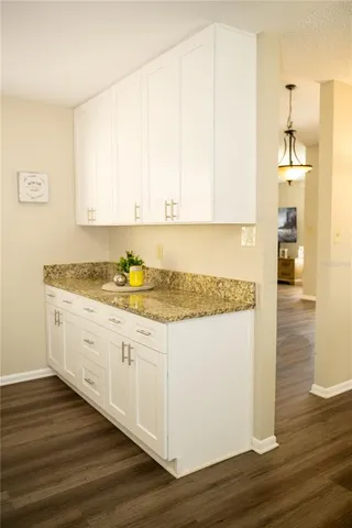 a kitchen with stainless steel appliances a dining table chairs stove refrigerator and wooden floor