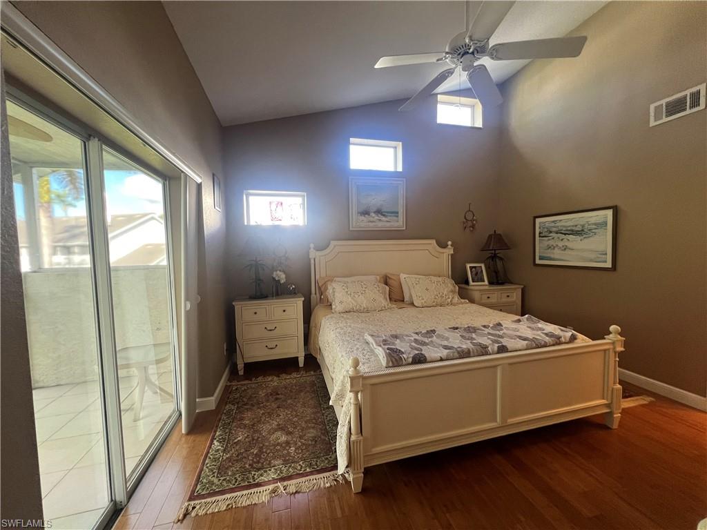 975 Partridge Circle, Unit 202 Naples, FL 34104 - Photo 3 of 16 a bedroom with a bed and a chandelier