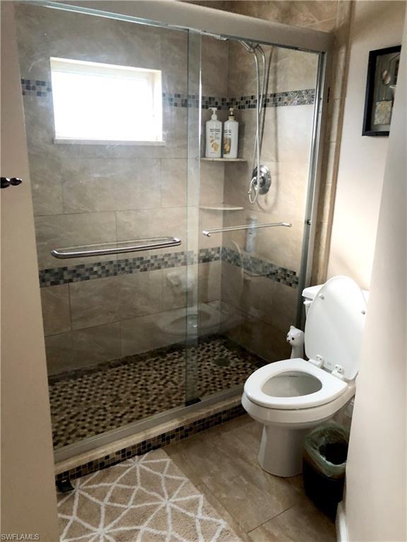 975 Partridge Circle, Unit 202 Naples, FL 34104 - Photo 5 of 16 a bathroom with a toilet and a shower