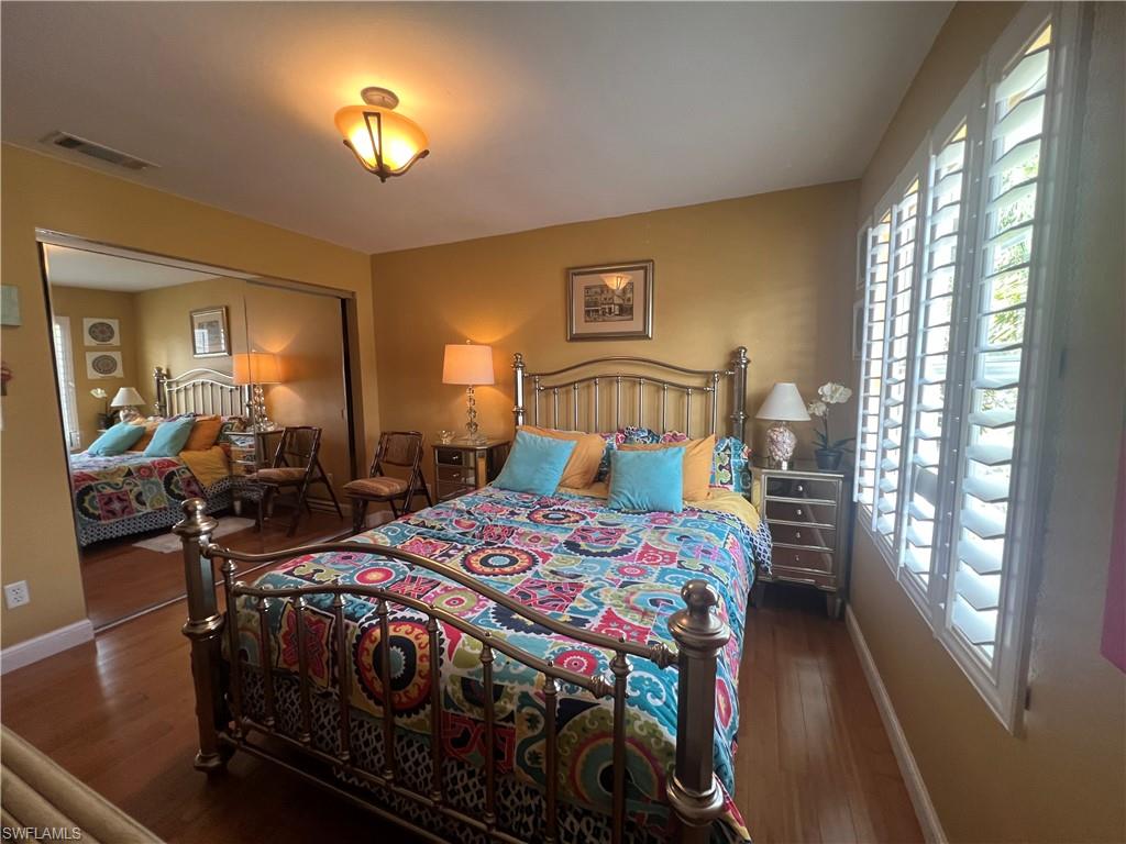 975 Partridge Circle, Unit 202 Naples, FL 34104 - Photo 6 of 16 a bedroom with a bed and a chandelier