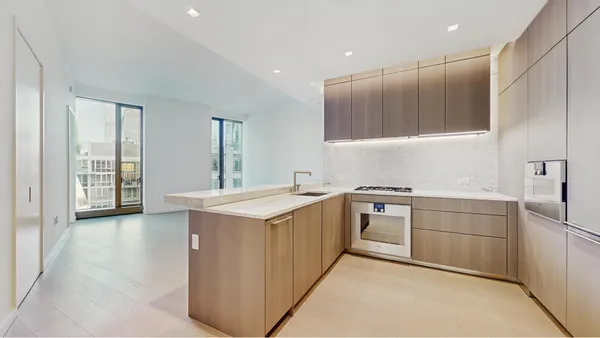 a view of kitchen with stainless steel appliances granite countertop cabinets and wooden floor