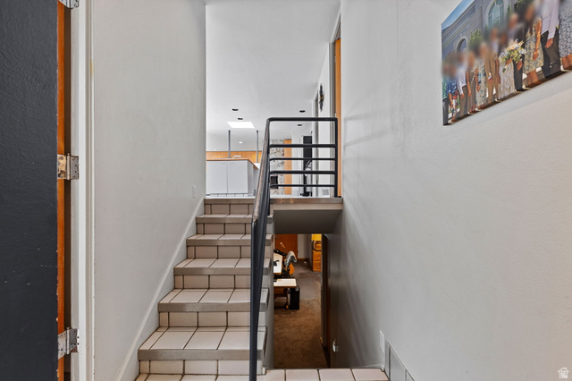 1856 Fort Canyon Road Alpine, UT 84004 - Photo 29 of 49 Multi-level interior featuring tile stairs with dark grout, a metal handrail, white walls, and a visible skylight