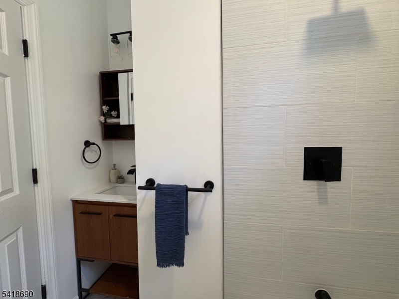 456 Harrison Street, Unit 2 Passaic, NJ 07055 - Photo 14 of 17 a bathroom with a sink a mirror and shower