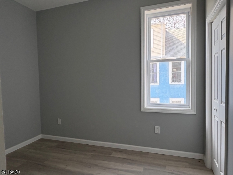 456 Harrison Street, Unit 2 Passaic, NJ 07055 - Photo 15 of 17 an empty room with wooden floor and windows