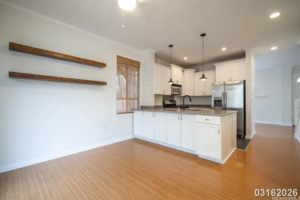 a kitchen with a refrigerator and white cabinets
