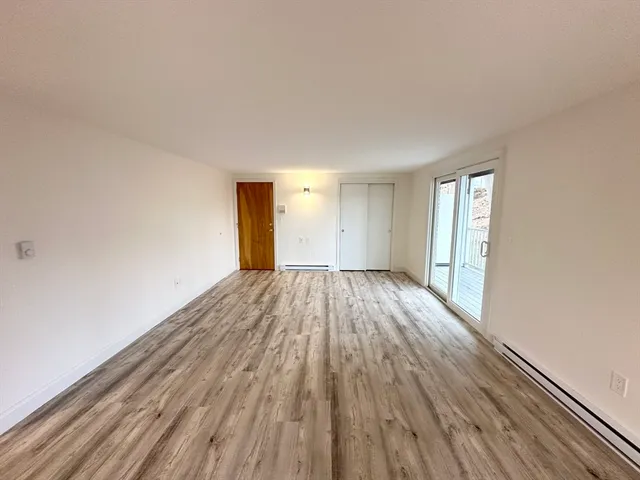 a view of a room with wooden floor and window