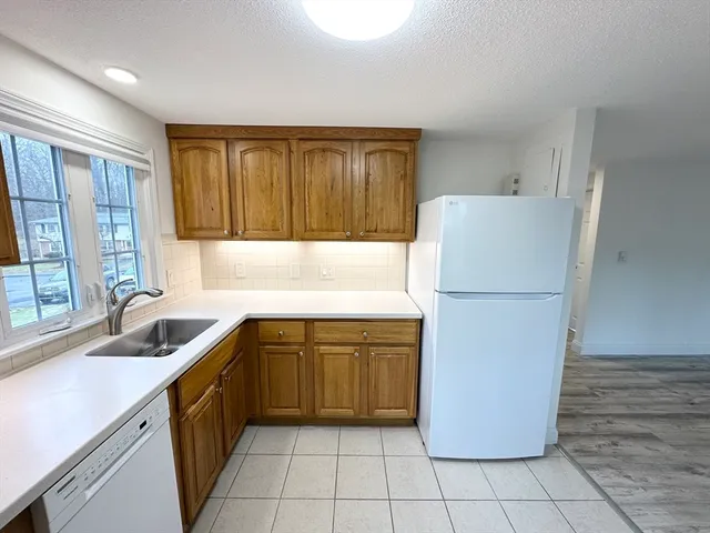 a kitchen with a refrigerator sink and cabinets