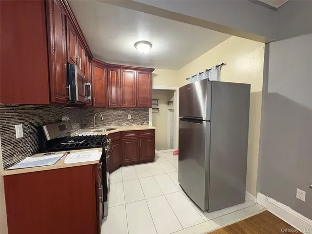 a kitchen with stainless steel appliances granite countertop a refrigerator a stove a sink and a oven