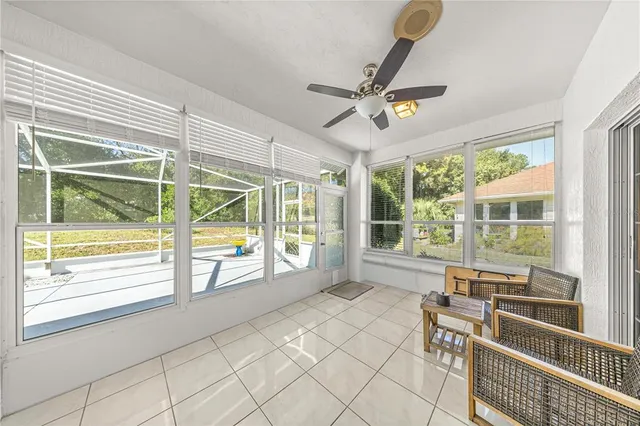 a living room with a large window and chairs