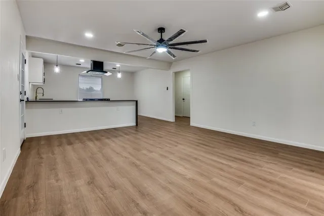 a view of a kitchen with a sink and wooden floor