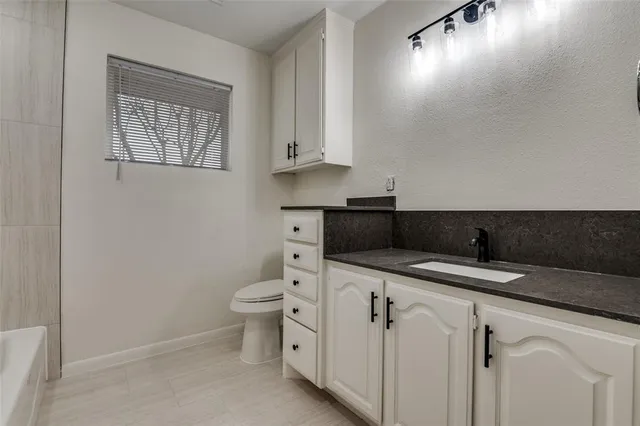 a bathroom with a sink a toilet and vanity