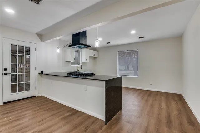 a kitchen with stainless steel appliances granite countertop a stove and a wooden floors