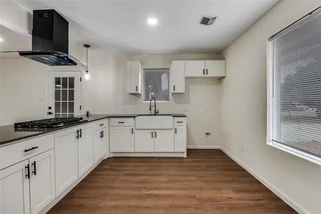 a kitchen with granite countertop a sink stainless steel appliances and cabinets