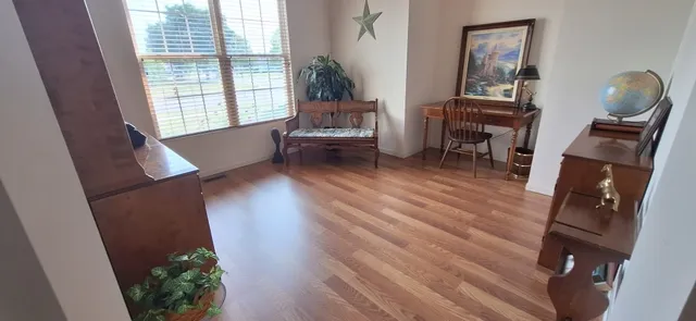 a bedroom with a bed and a dresser next to a window