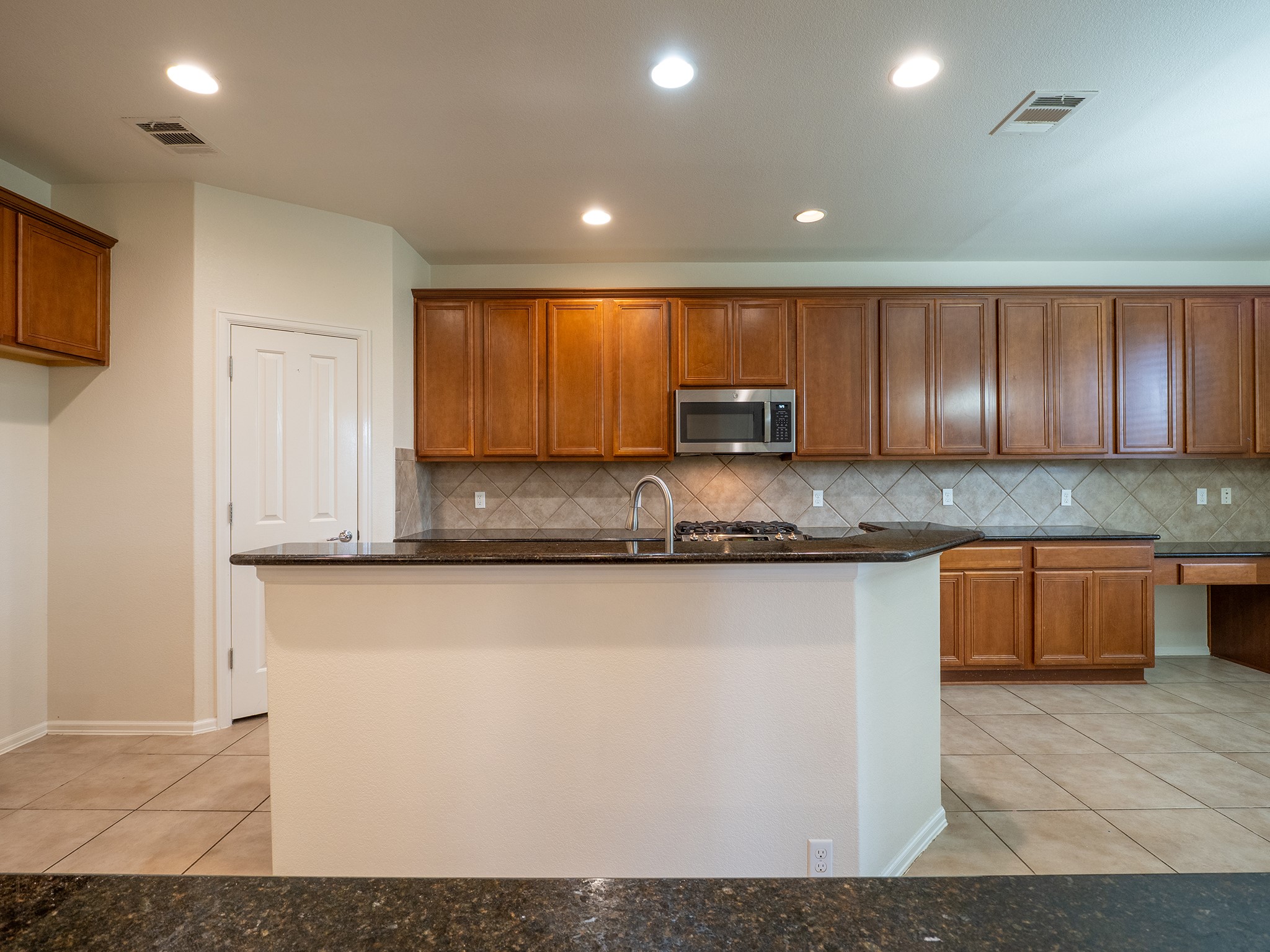 572 Big Meadow Road Austin, TX 78737 - Photo 5 of 32 Ample cabinetry and stone countertops elevate this well-appointed kitchen.