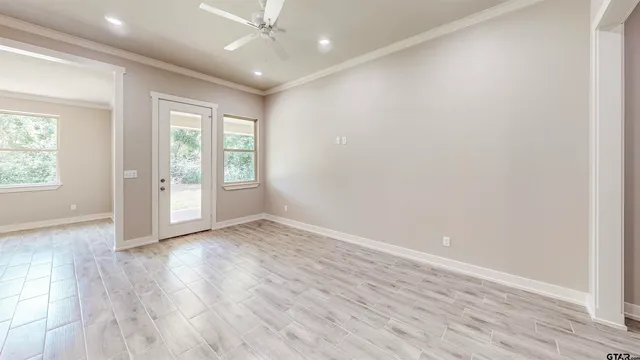 an empty room with wooden floor and windows