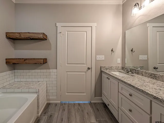 a bathroom with a granite countertop sink and a mirror